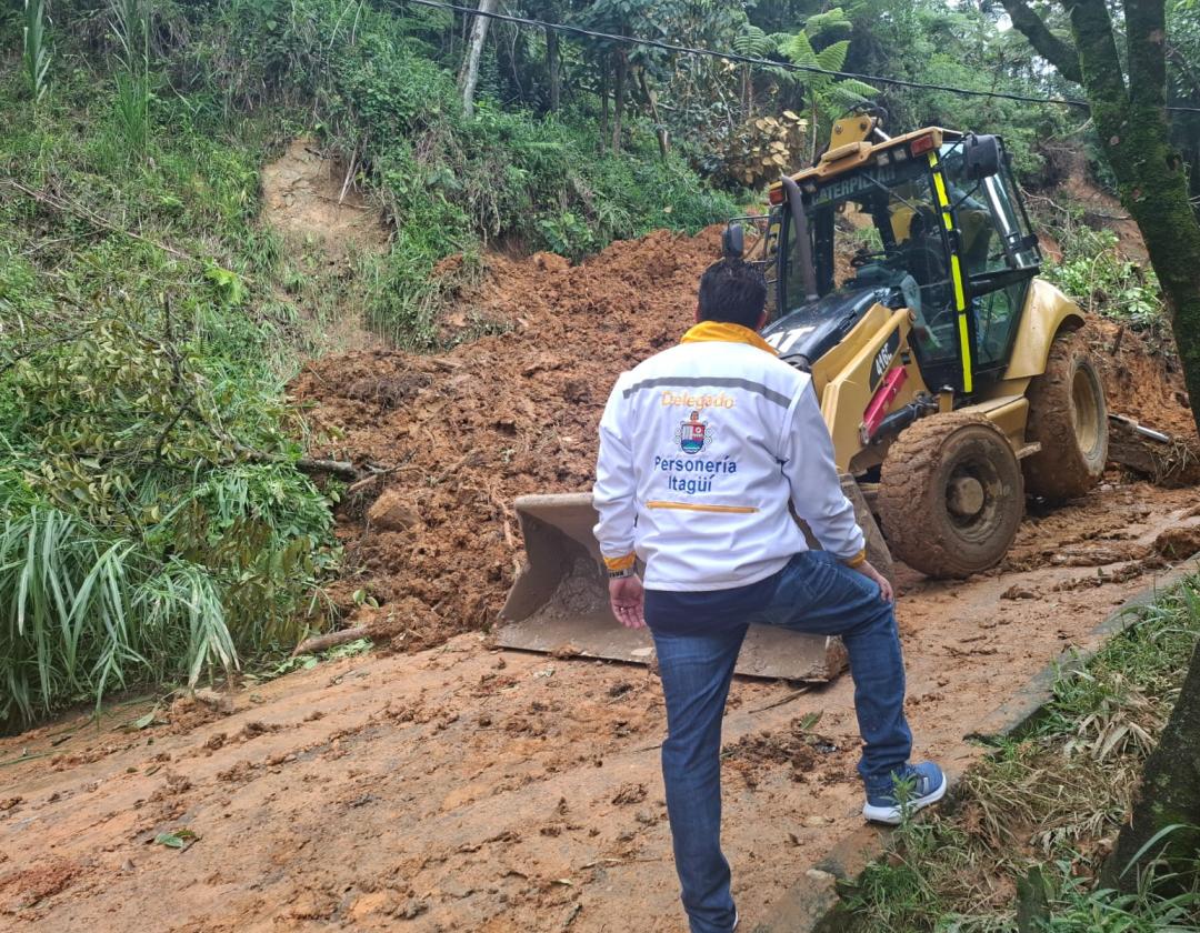 El delegado para los derechos humanos hace presencia en los sitios afectados por las fuertes lluvias. Se observa frente a una zona llena de lodo y una máquina retroexcabadora