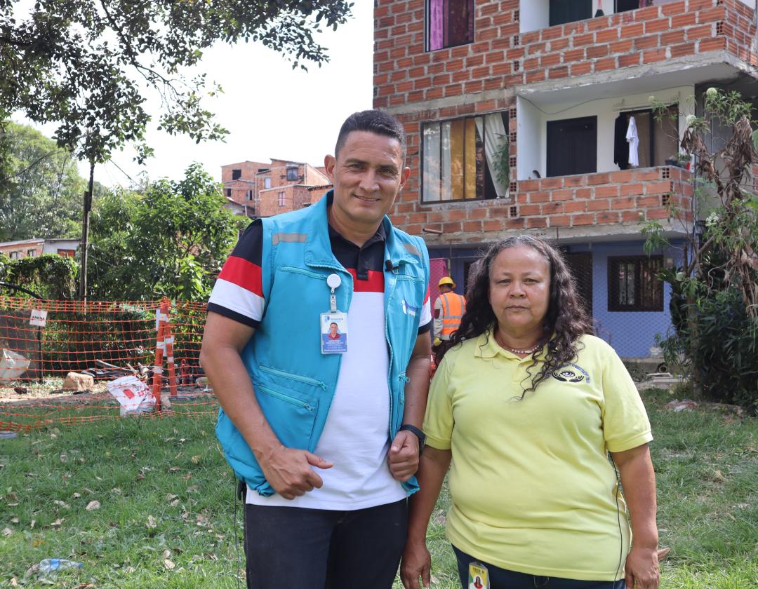 Personero Delegado Jhon Fredy Hernández Vallejo junto a  la veedora ciudadana Ángela María Zapata Acevedo, en un entrono con pasto y una obra detrás. 